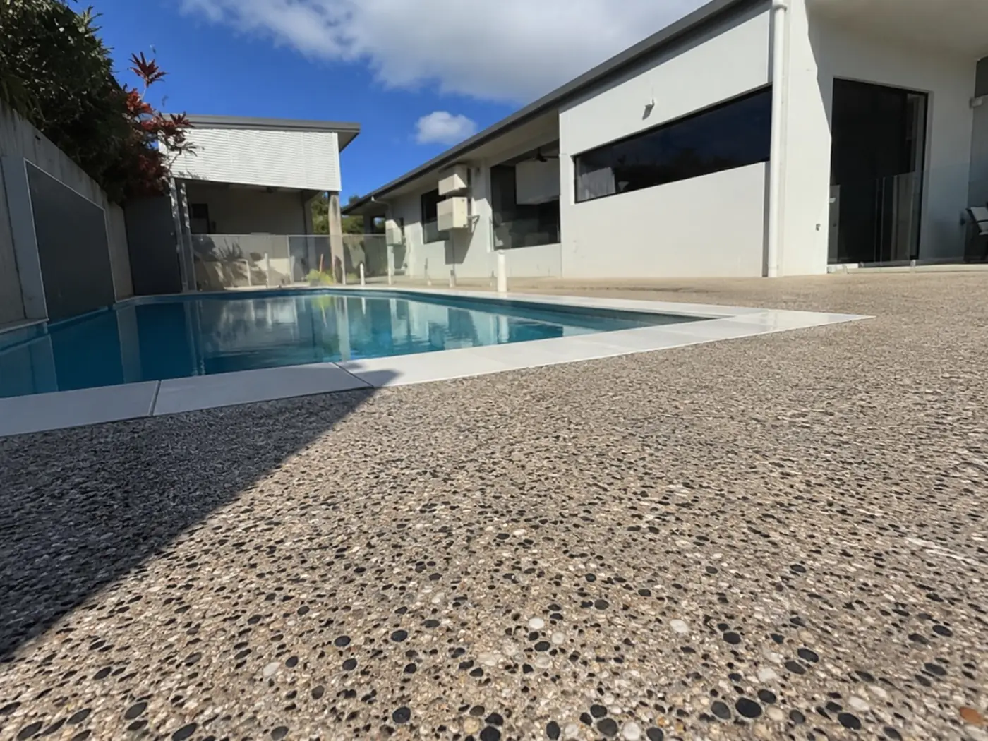 Lap pool framed by an exposed aggregate surround at a contemporary Darwin home